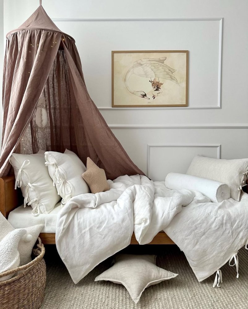 Útulná posteľ s baldachýnom a dekoratívnymi vankúšmi v prírodných farbách